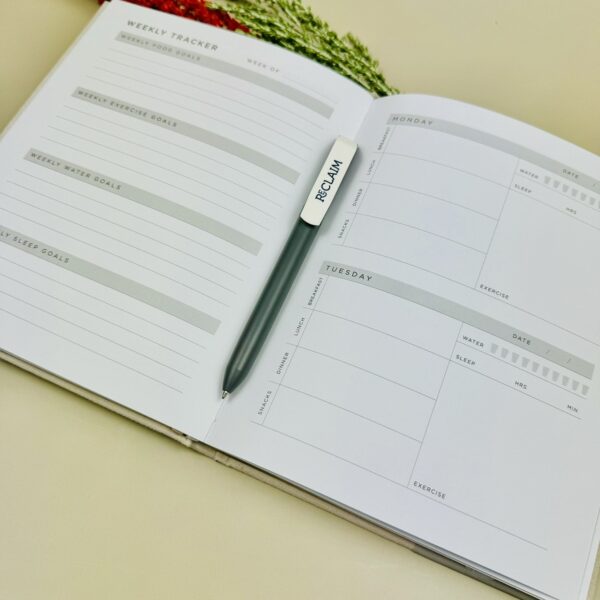 A picture of the Wellness Journal and a Vent Reclaim pen that is included in the Yoga Wellness Gift Hamper