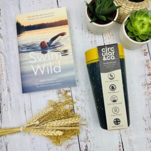 A picture of the Swim Wild Book by Jack Hudson and the Circular and Co travel mug that are inlcuded in the Swim Wild Gift Box. This is a thoughtful gift for wild swimmer enthusiasts.