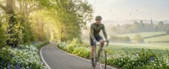 A picture of a cyclist on a road enjoying the spring time. This is used for the Cycling gift for men blog.