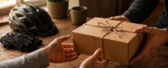 A picture of a person receiving a gift with cycling gear in the background. This is being used for the gifts for cyclists blog.